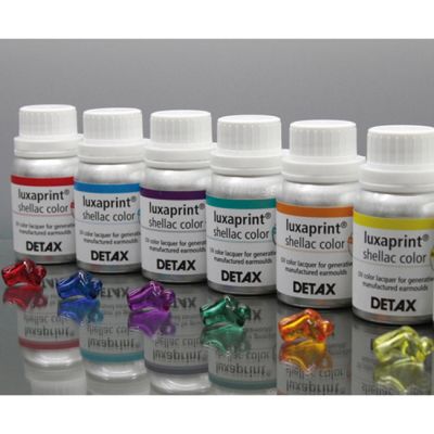 Detax Luxaprint shellac color in bottles with earmolds showing different colors.